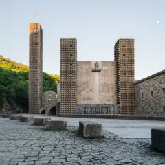 Santuario de Arantzazu con su torre alta, fachada de piedra y esculturas.