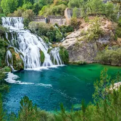 Cascada y laguna de Uña, con aguas turquesas y vegetación exuberante.