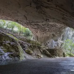 Interior de una cueva con escaleras de madera y piedra que llevan al exterior. Para saber zugarramurdi como llegar, sigue el camino.