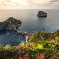 Las escaleras de San Juan de Gaztelugatxe serpentean hacia una ermita en una isla rocosa, rodeada por el mar Cantábrico.