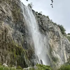 Majestuosa cascada del Ason cayendo por un imponente acantilado rocoso cubierto de vegetación.