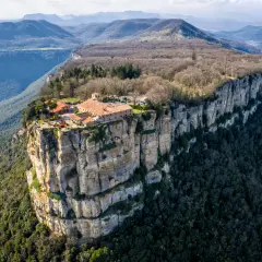 El santuari del Far se alza majestuoso sobre un acantilado, rodeado de montañas y bosques.
