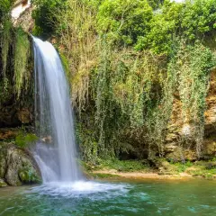 Cascadas en Burgos, un rincón verde y exuberante donde el agua cae sobre rocas cubiertas de musgo y enredaderas.