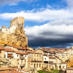 Pueblo medieval en un risco rocoso, con un castillo en la cima. Las casas se aferran a la ladera. Frias como llegar, un destino histórico.