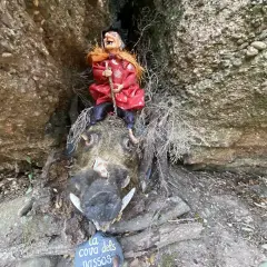 Bruja sentada sobre un jabalí disecado en el Bosc de les Bruixes. La cueva de los narices.