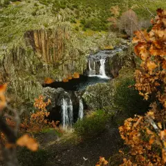 Cascada del Aljibe en otoño, con hojas doradas y rocas cubiertas de musgo.