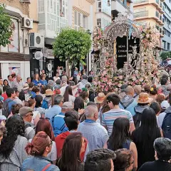 Multitud celebra procesión con un carro adornado con flores. Se pregunta: ¿dónde está el rocío?