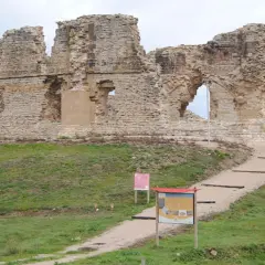 Ruinas del castillo de Tiebas, con escalones de acceso y paneles informativos.