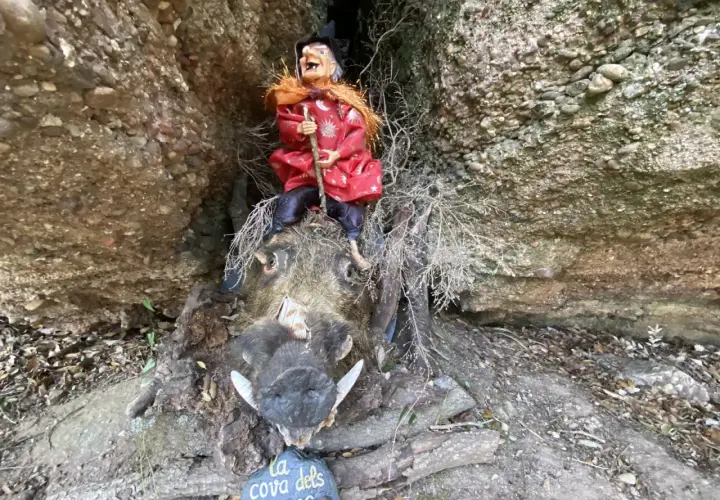 Bruja sentada sobre un jabalí disecado en el Bosc de les Bruixes. La cueva de los narices.