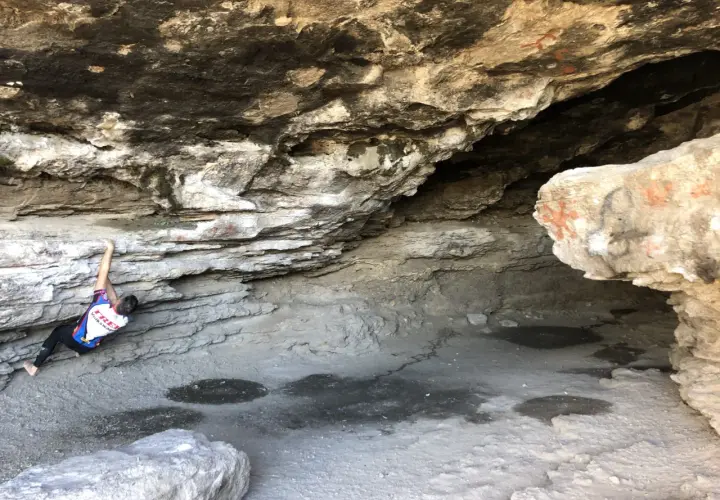 Escalador en roca bajo un saliente rocoso, cerca de las cumbres verdes Granada.