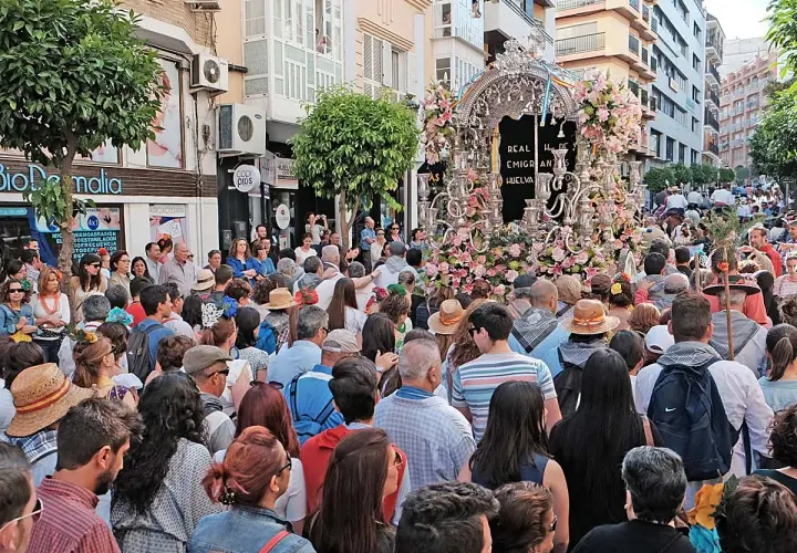 Multitud celebra procesión con un carro adornado con flores. Se pregunta: ¿dónde está el rocío?