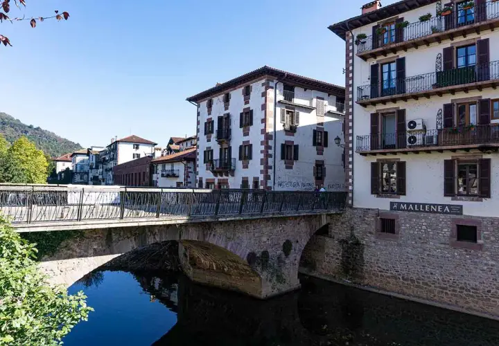 Puente de piedra y casas blancas con balcones en Elizondo. Un lugar pintoresco para visitar.
