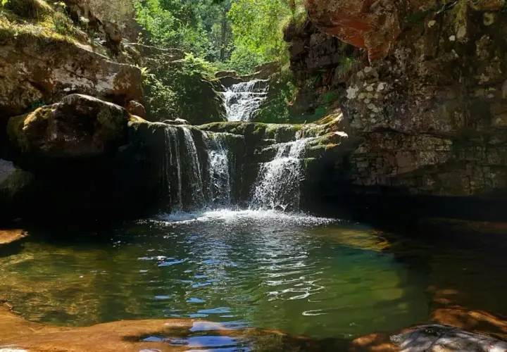 Cascadas de Puente Ra, un rincón natural con agua cristalina y rocas cubiertas de musgo.