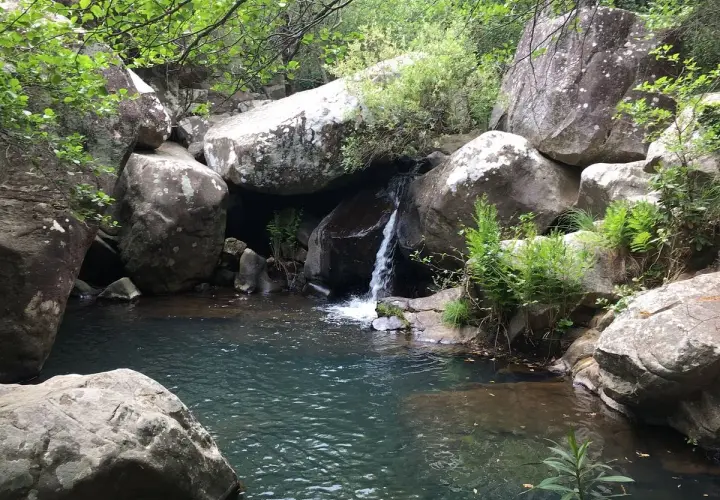 Pequeña cascada en la garganta del capitán, rodeada de rocas y vegetación exuberante.