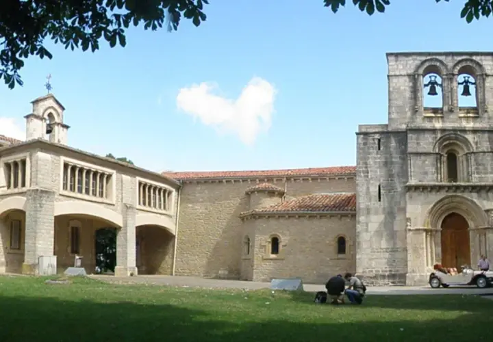 El **santuario de Estíbaliz**, con su torre románica y un coche clásico aparcado, invita a la contemplación.