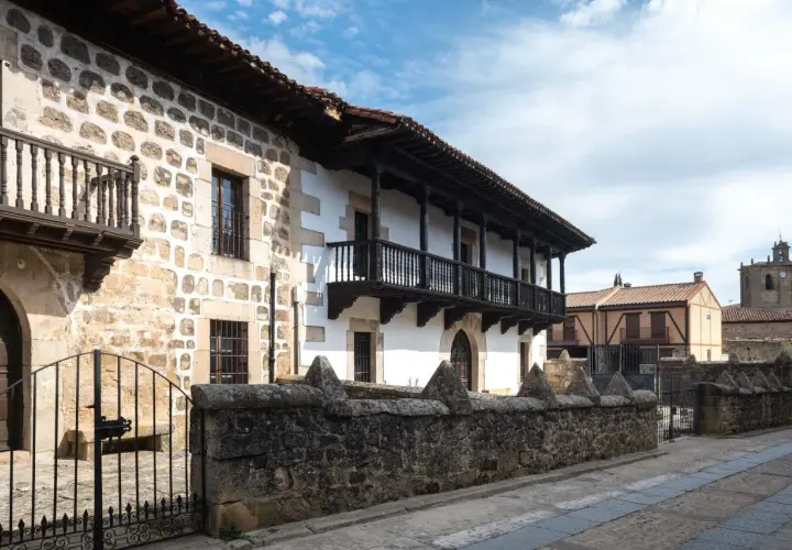 Edificio tradicional con balcones de madera y muros de piedra. Si buscas cómo llegar a Vinuesa, este es el tipo de arquitectura que encontrarás.