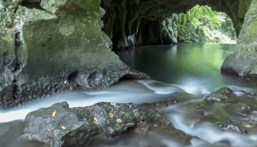 Agua serena fluye en la **gruta del diablo**, un lugar misterioso y verde.