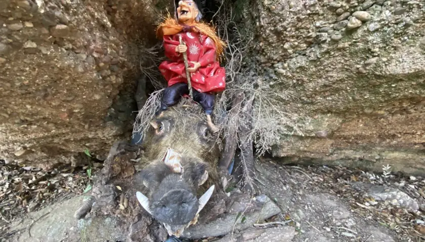Bruja sentada sobre un jabalí disecado en el Bosc de les Bruixes. La cueva de los narices.