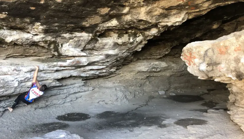 Escalador en roca bajo un saliente rocoso, cerca de las cumbres verdes Granada.