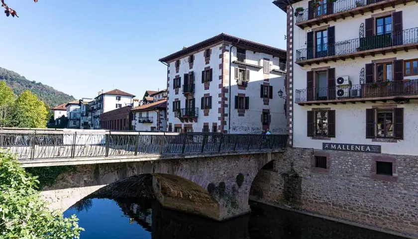 Puente de piedra y casas blancas con balcones en Elizondo. Un lugar pintoresco para visitar.