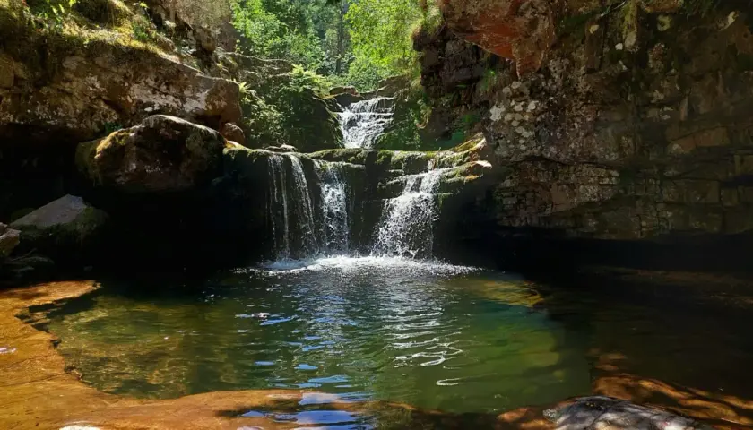 Cascadas de Puente Ra, un rincón natural con agua cristalina y rocas cubiertas de musgo.