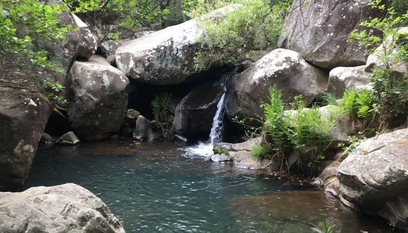 Pequeña cascada en la garganta del capitán, rodeada de rocas y vegetación exuberante.