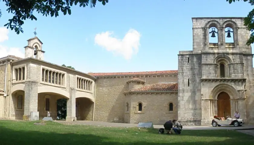 El **santuario de Estíbaliz**, con su torre románica y un coche clásico aparcado, invita a la contemplación.