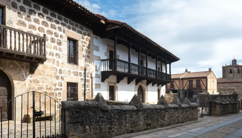 Edificio tradicional con balcones de madera y muros de piedra. Si buscas cómo llegar a Vinuesa, este es el tipo de arquitectura que encontrarás.