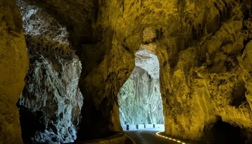 Un camino serpentea a través de las impresionantes cuevas del agua, iluminado por luces doradas que resaltan las formaciones rocosas.