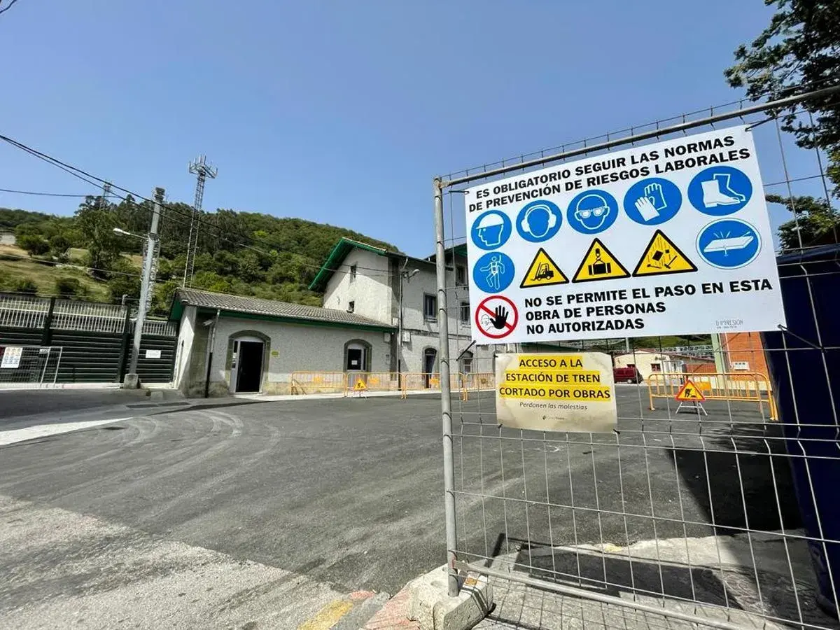 Señalización de obras en la estación de tren de Pola de Lena. Indica acceso restringido y normas de seguridad.