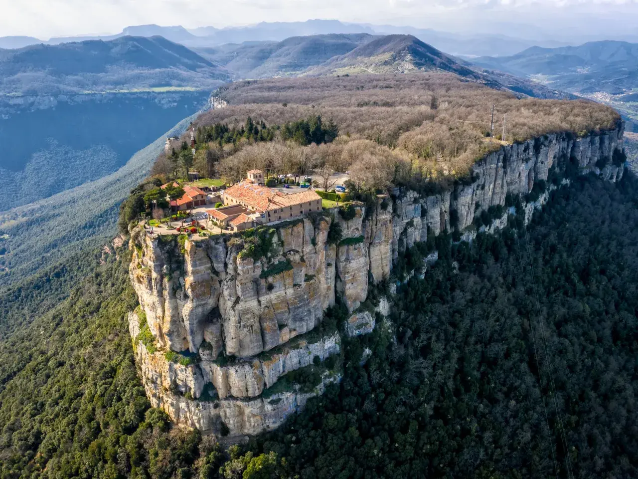 El santuari del Far se alza majestuoso sobre un acantilado, rodeado de montañas y bosques.