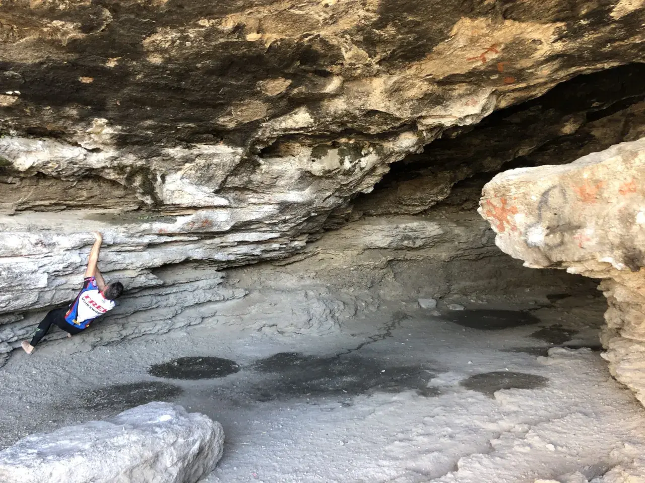 Escalador en roca bajo un saliente rocoso, cerca de las cumbres verdes Granada.