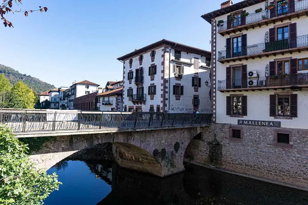 Puente de piedra y casas blancas con balcones en Elizondo. Un lugar pintoresco para visitar.