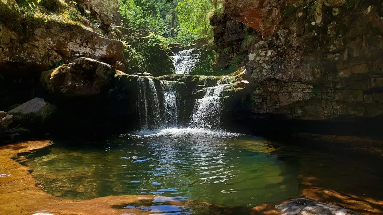 Cascadas de Puente Ra, un rincón natural con agua cristalina y rocas cubiertas de musgo.