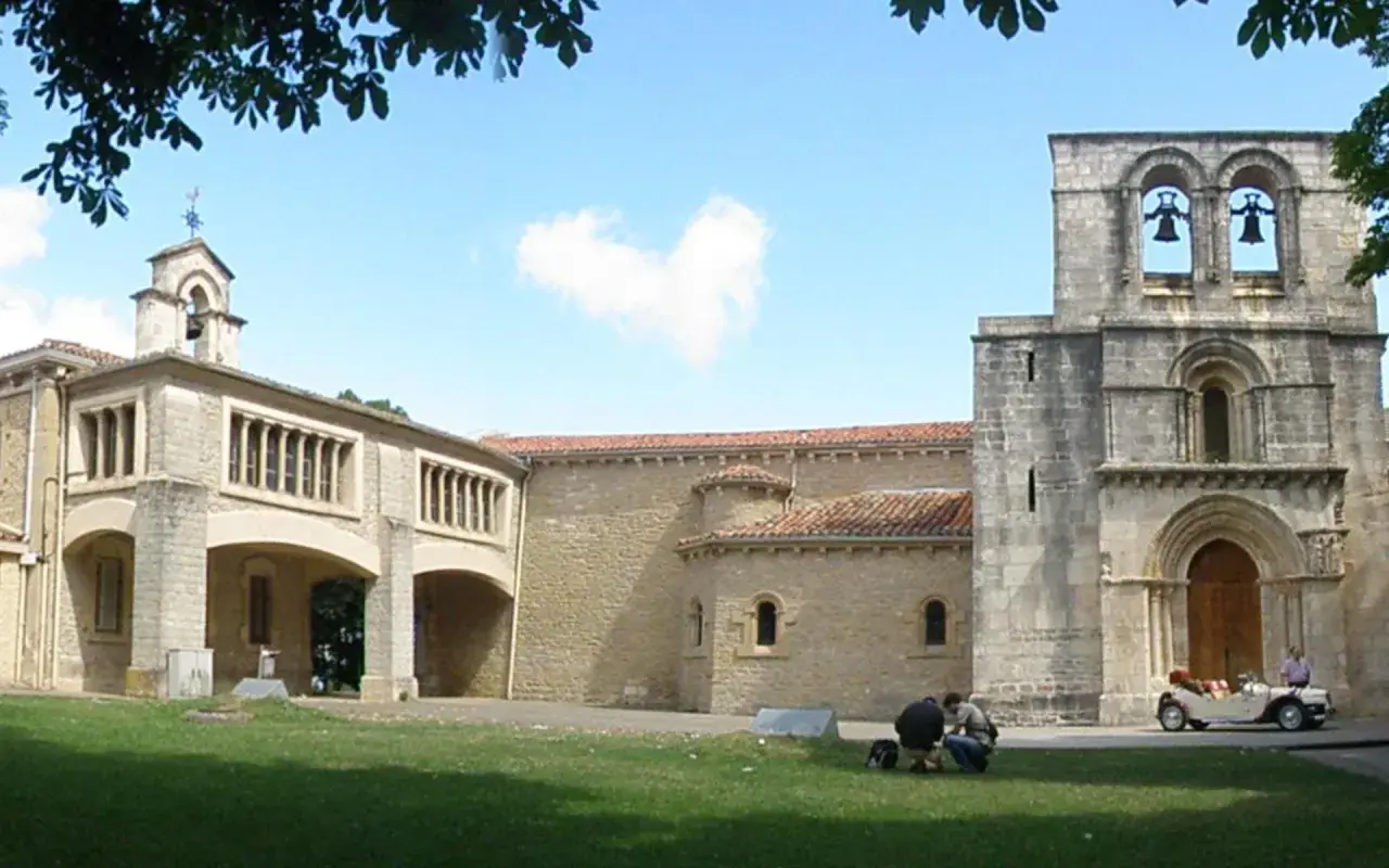 El **santuario de Estíbaliz**, con su torre románica y un coche clásico aparcado, invita a la contemplación.