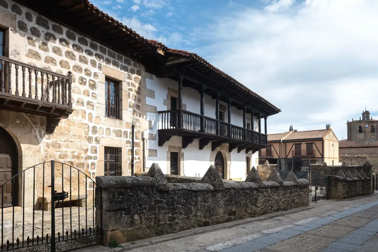 Edificio tradicional con balcones de madera y muros de piedra. Si buscas cómo llegar a Vinuesa, este es el tipo de arquitectura que encontrarás.