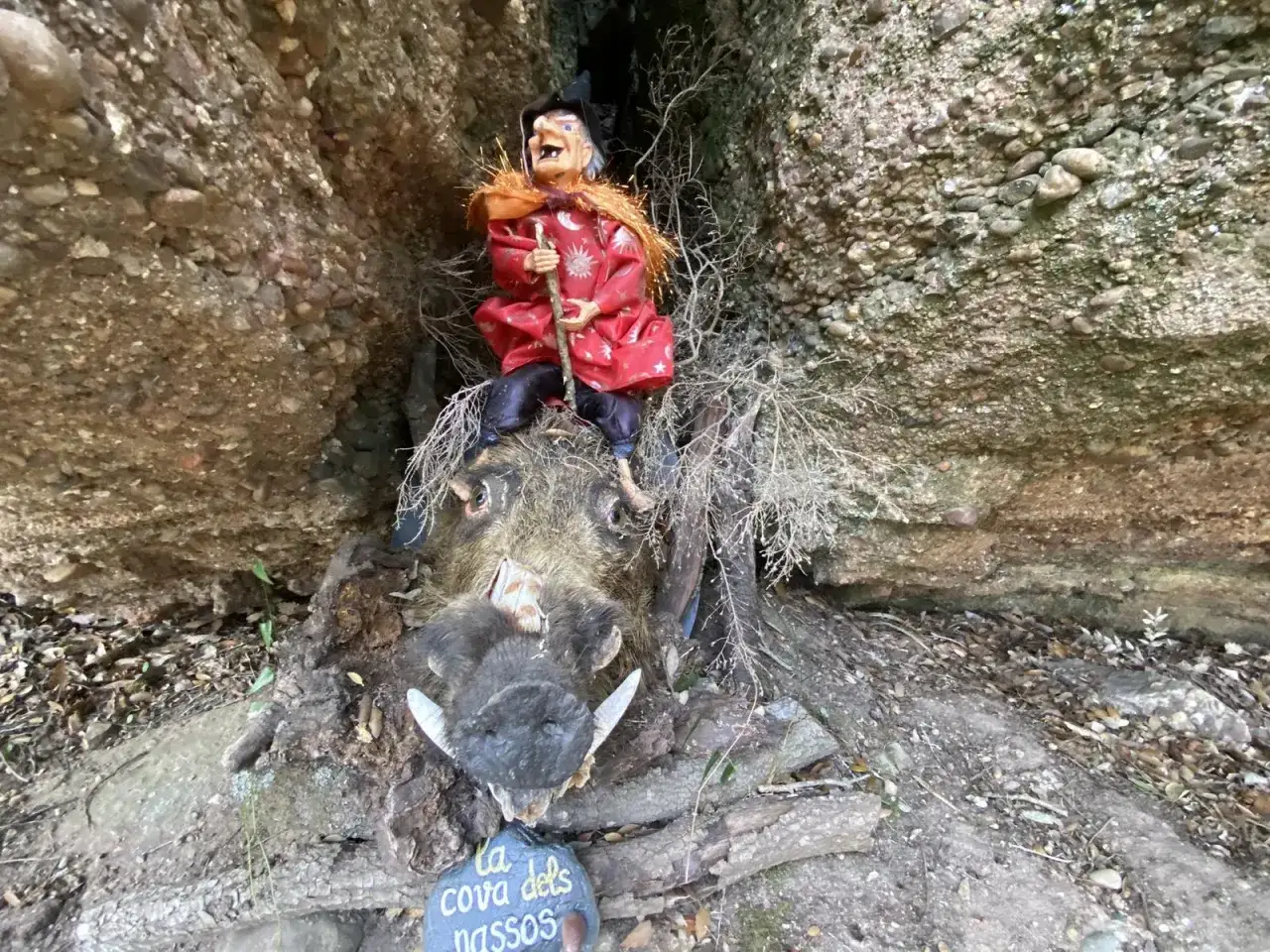 Una bruja sentada sobre un jabalí disecado en el Bosc de les Bruixes. La cueva de los narices.