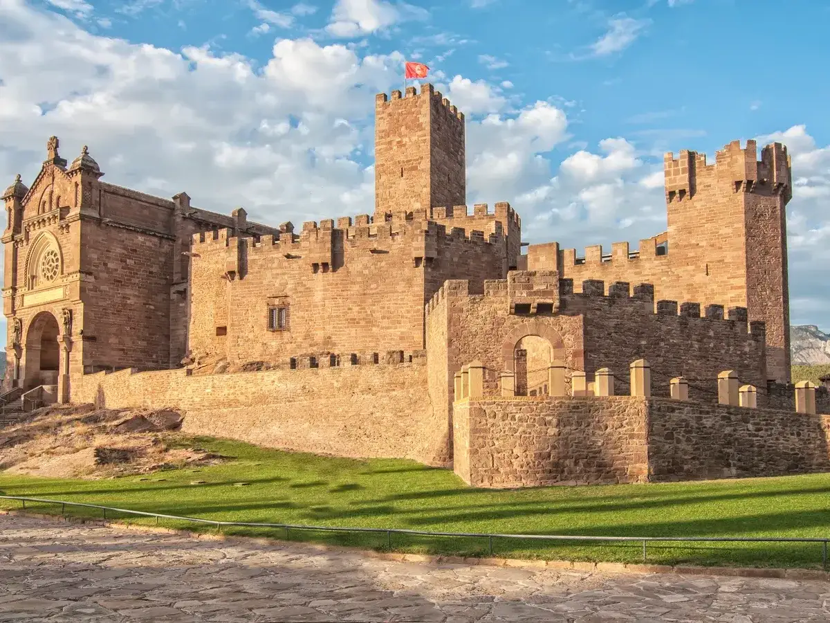 Imponente castillo de Javier, con sus torres de piedra y un cielo azul con nubes.