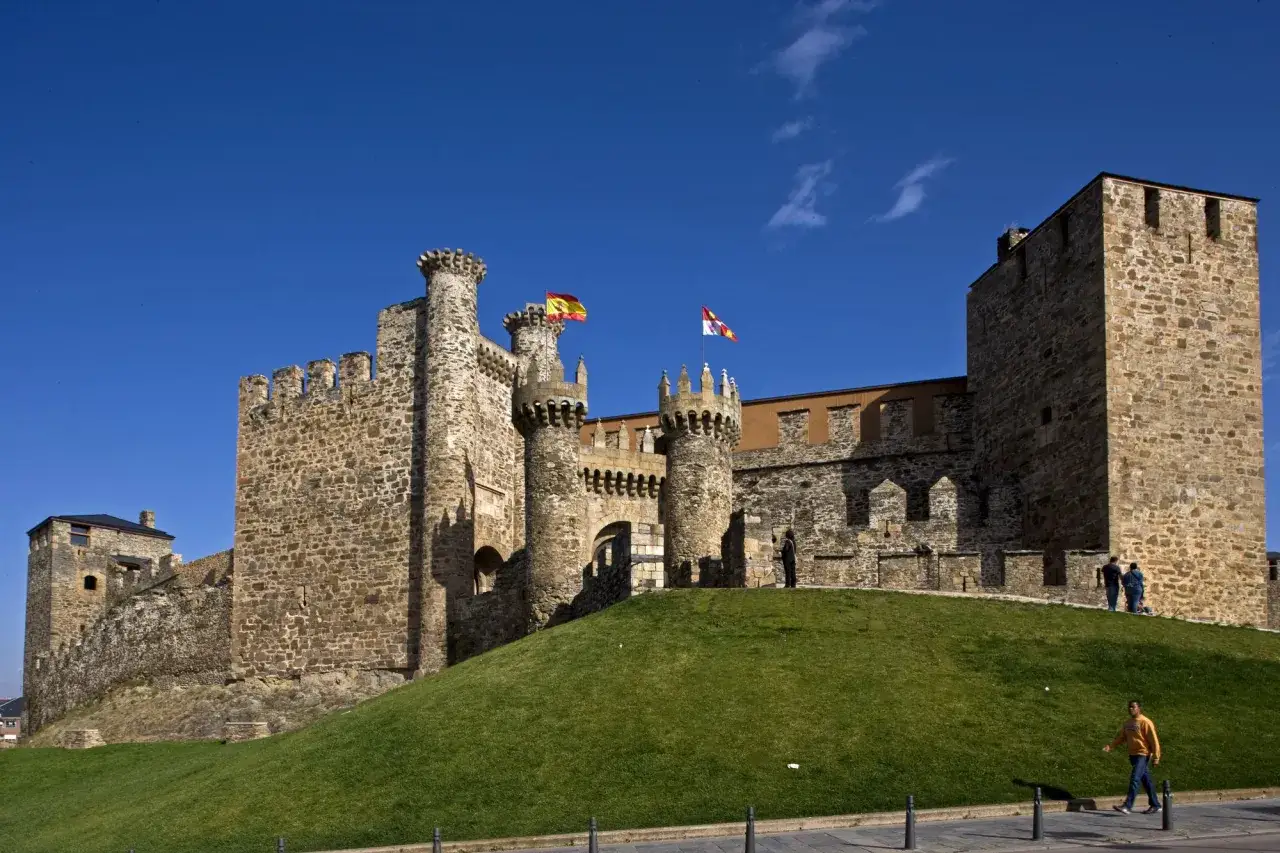 Castillo de Ponferrada, donde est&aacute; Ponferrada, con sus torres y murallas de piedra bajo un cielo azul.