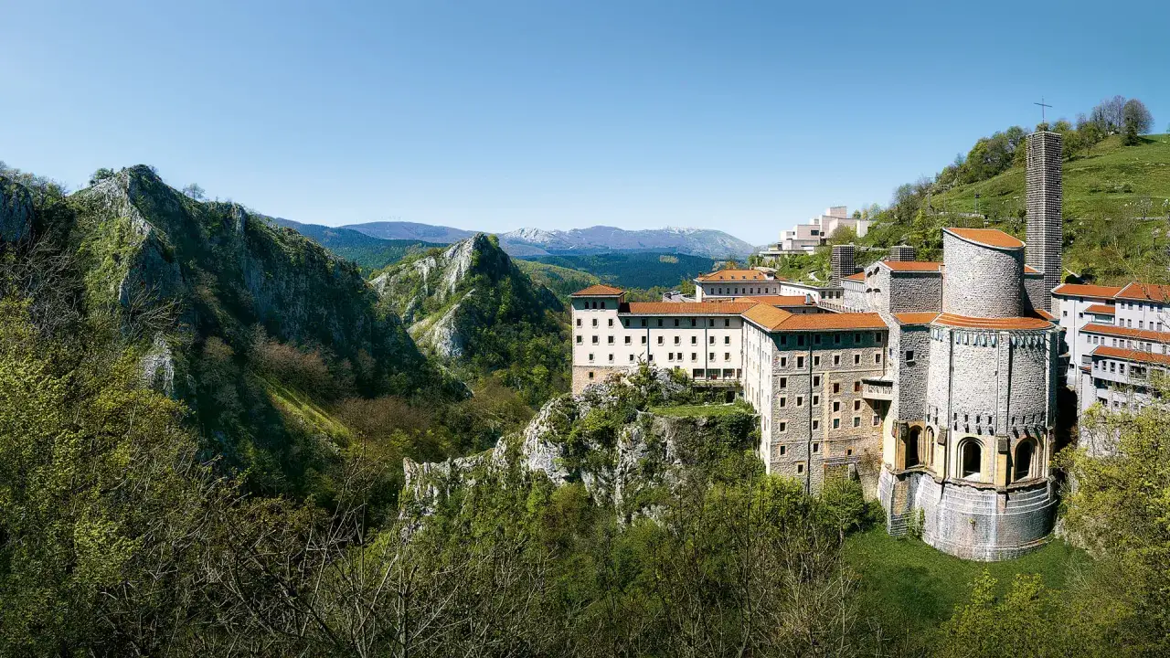 Santuario de la Virgen de Aránzazu, un complejo religioso enclavado en un paisaje montañoso verde y rocoso.