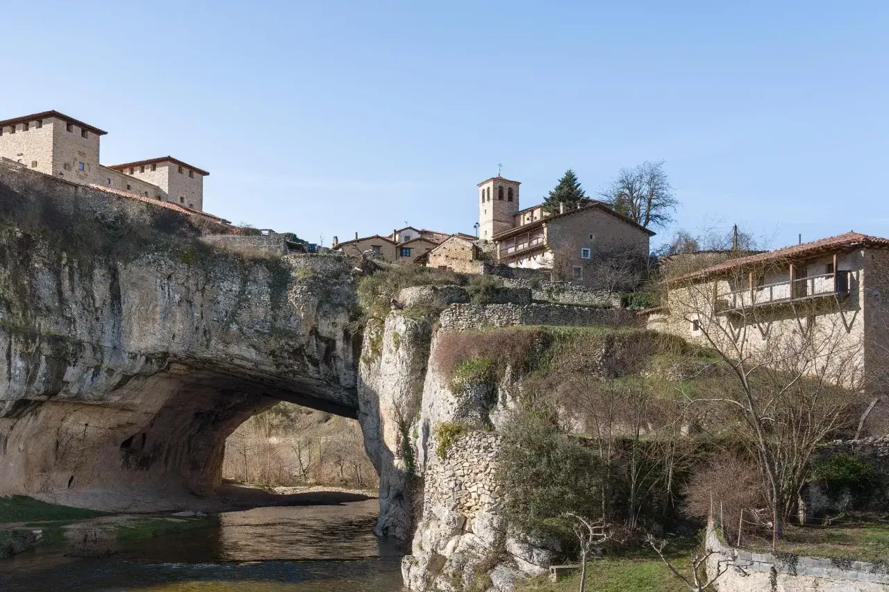 Pueblo con casas de piedra sobre un arco natural en el río. Descubre cómo llegar a este puente de ensueño.