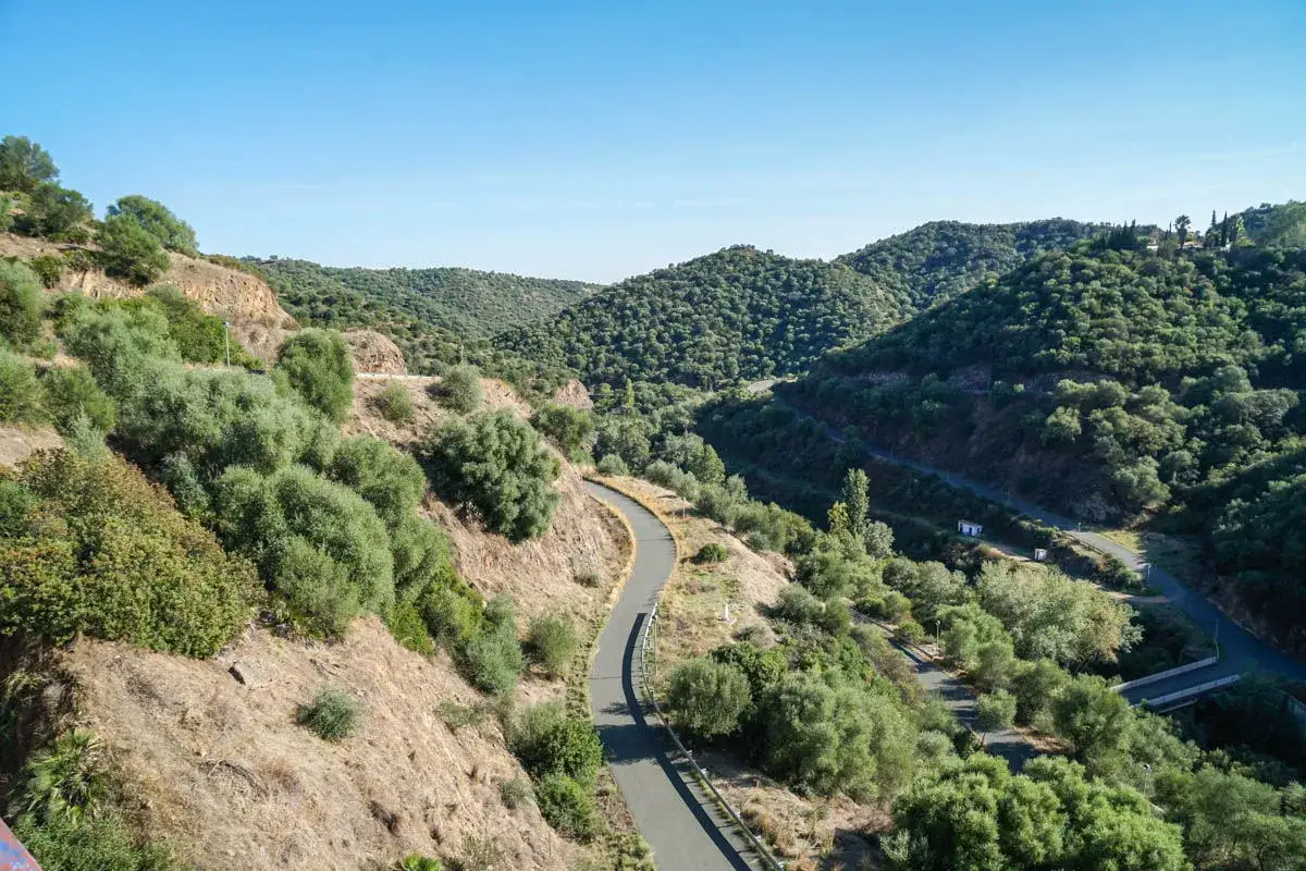 Carretera serpenteante entre colinas verdes y secas, ideal para explorar cómo llegar a Constantina.