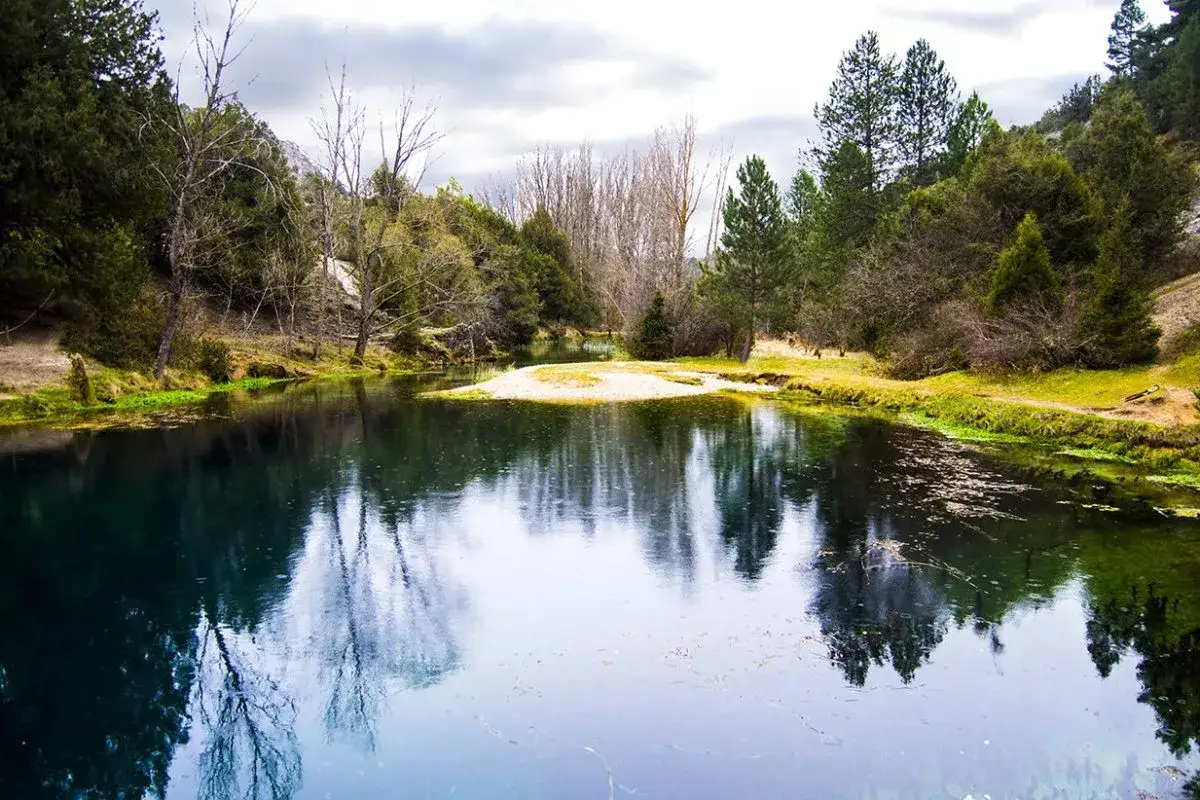 La fuentona de Muriel, un remanso de paz con aguas cristalinas y reflejos de árboles frondosos.