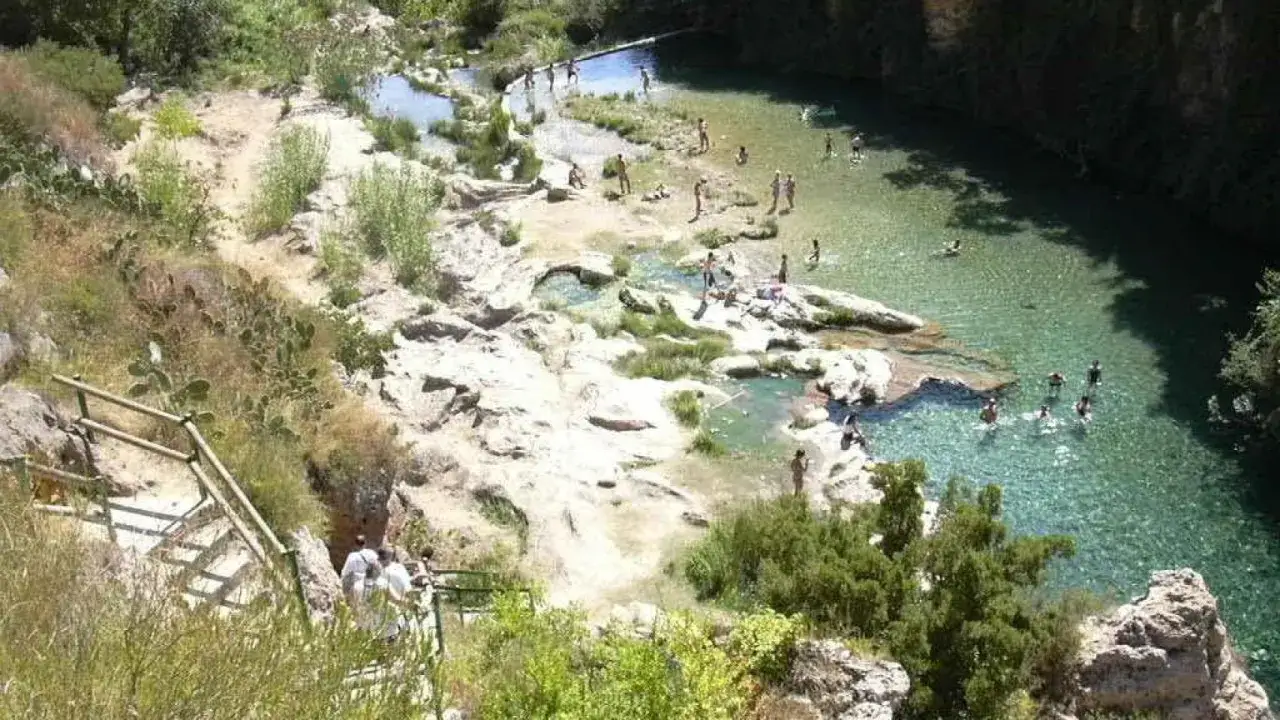 Gente disfrutando de las cascadas de Anna, un oasis de aguas cristalinas y rocas.