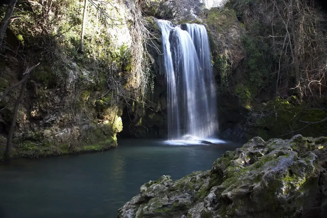 Cascadas de Hueznar, un espect&aacute;culo natural de agua cayendo entre rocas cubiertas de musgo y vegetaci&oacute;n exuberante.