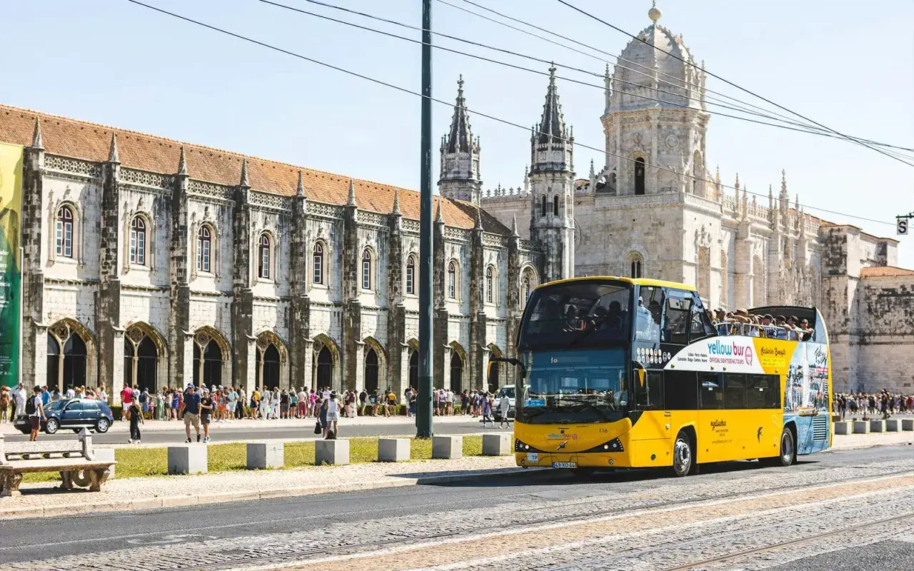 Autobús turístico amarillo frente al Monasterio de los Jerónimos, ideal para saber como ir de Lisboa a Sintra.