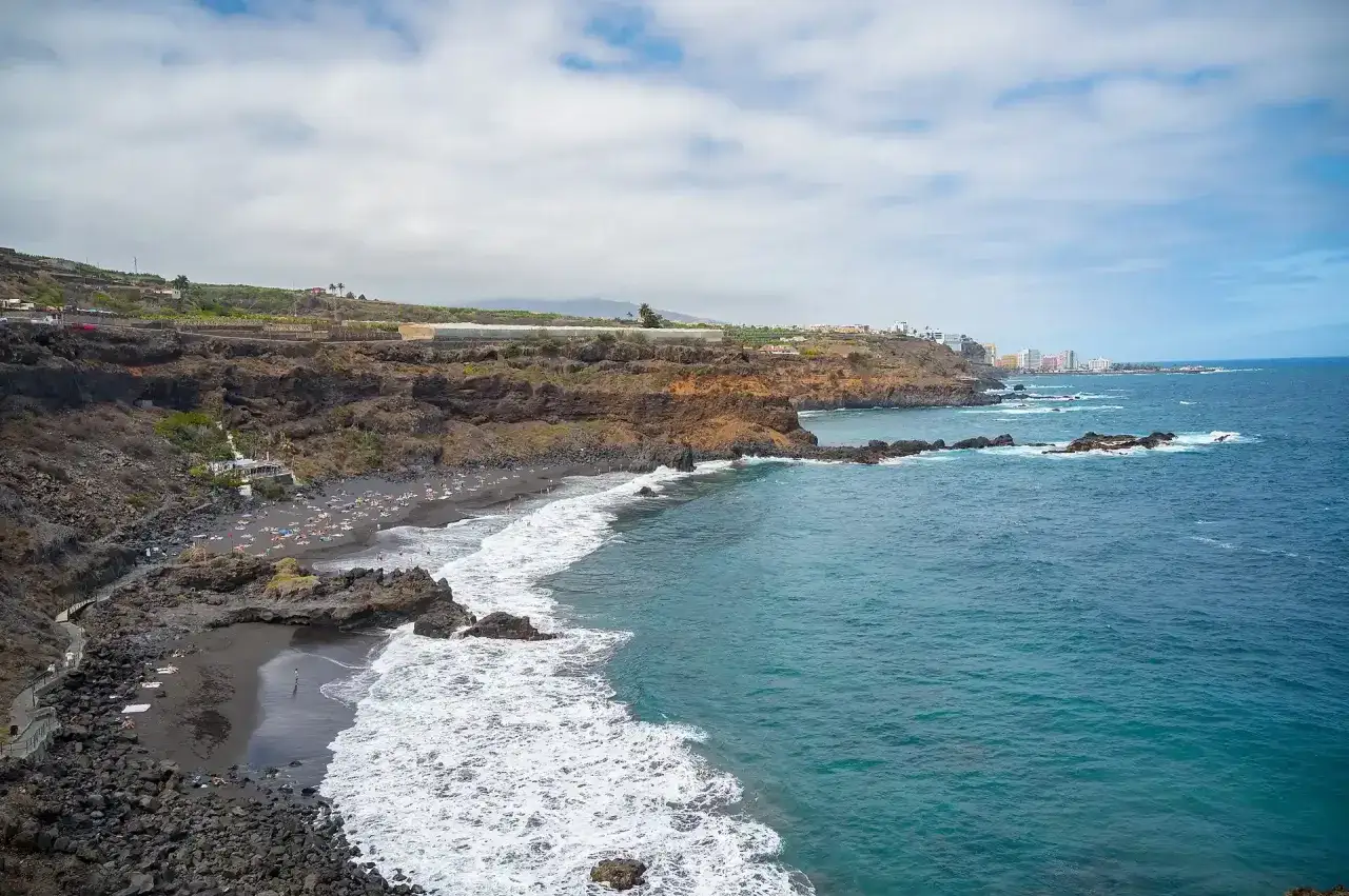 Costa volcánica con playa de arena negra y aguas turquesas, un paraíso entre las mejores playas de Tenerife.
