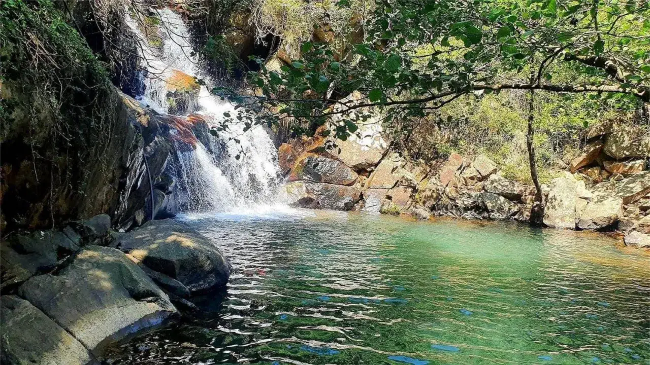 Cascada en la garganta del capit&aacute;n, con agua verde cristalina y rocas cubiertas de vegetaci&oacute;n.