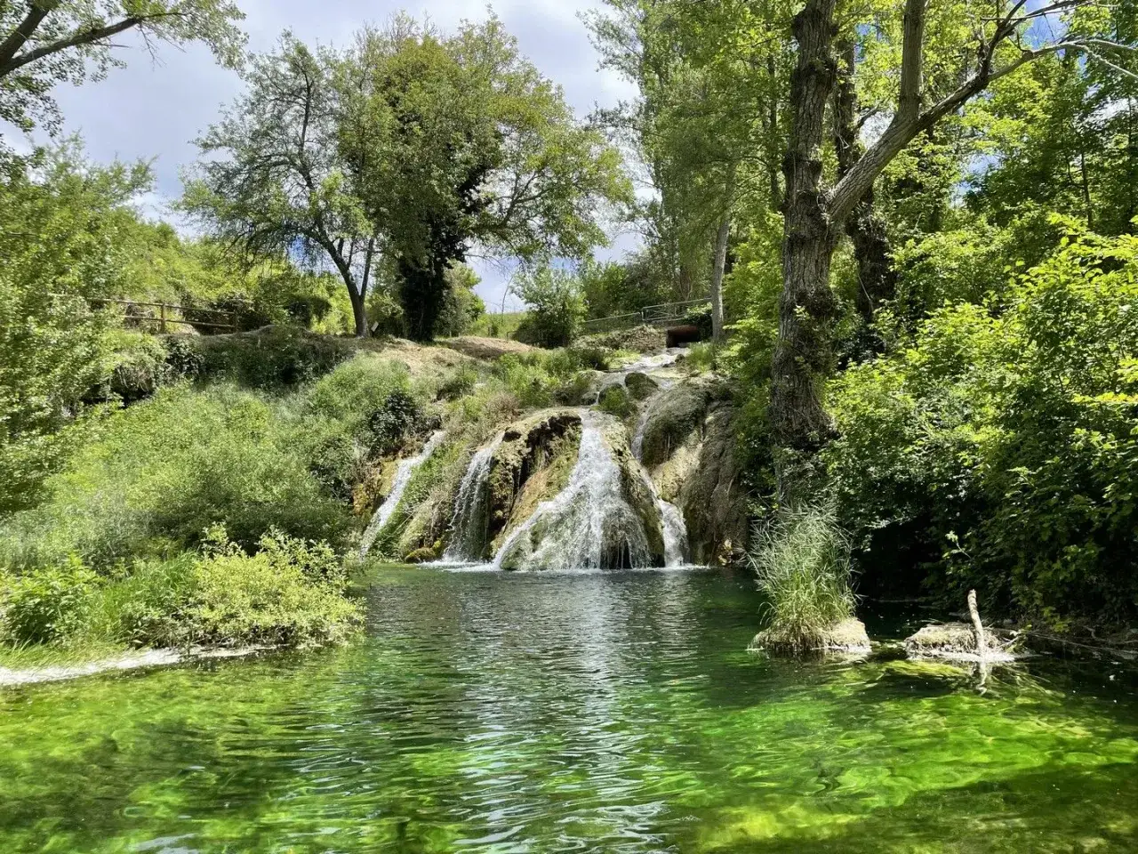 Cascadas en Burgos, un rincón verde y refrescante. El agua cristalina fluye entre rocas y vegetación exuberante, creando un paisaje idílico.